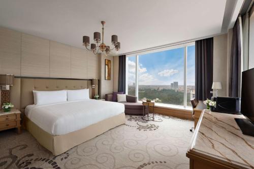 a hotel room with a bed and a large window at Shangri-La Bengaluru in Bengaluru