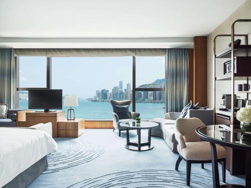 a hotel room with a bed and a view of the water at Kerry Hotel Hong Kong by Shangri-la in Hong Kong