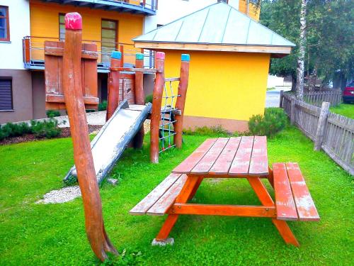 a playground with a wooden table and a slide at Apartmán Rokytka s balkonem in Rokytnice nad Jizerou