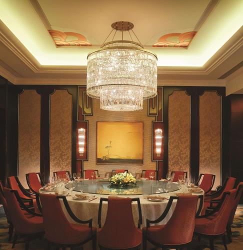 a dining room with a large table and a chandelier at Shangri-La Tianjin in Tianjin