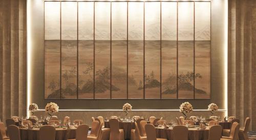 a dining room with tables and chairs and a large window at Shangri-La Tianjin in Tianjin