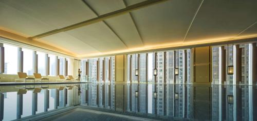 a large swimming pool in a building with windows at Shangri-La Tangshan in Tangshan