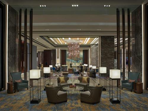a lobby of a hotel with couches and a chandelier at Shangri-La Songbei, Harbin in Harbin