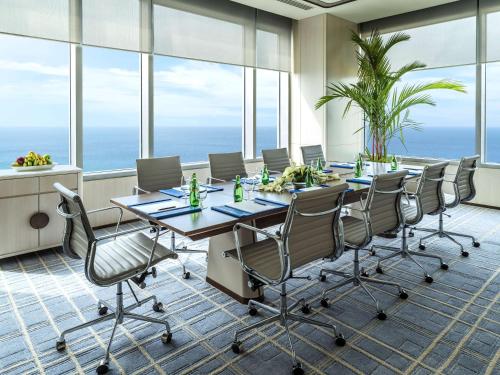 a conference room with a table and chairs and the ocean at Shangri-La Colombo in Colombo
