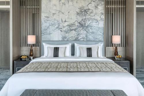 a bedroom with a large white bed with two lamps at Shangri-La Colombo in Colombo