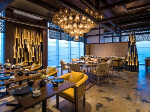 a dining room with tables and chairs and chandeliers at Shangri-La Colombo in Colombo