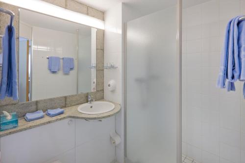 uma casa de banho com um lavatório e um chuveiro em Good Night Inn em Brig