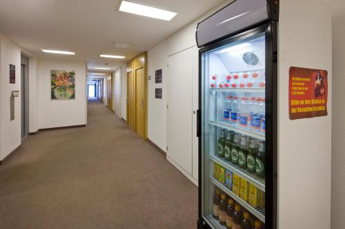 a hallway with a refrigerator full of drinks at Good Night Inn in Brig