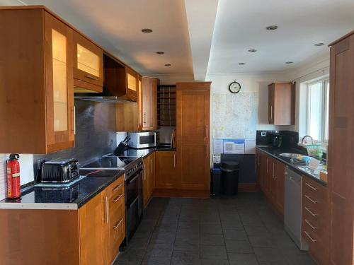 a kitchen with wooden cabinets and a stove top oven at Craster Crew House in Craster