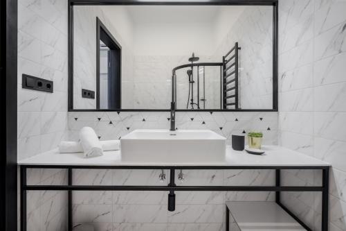 bagno bianco con lavandino e specchio di Astoria Boutique Suites- Best Location by BQA a Budapest