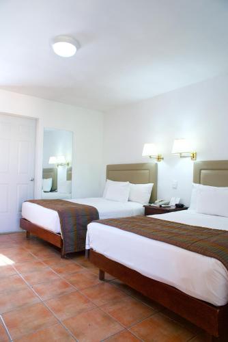 a hotel room with two beds and a tile floor at Best Western Saltillo in Saltillo