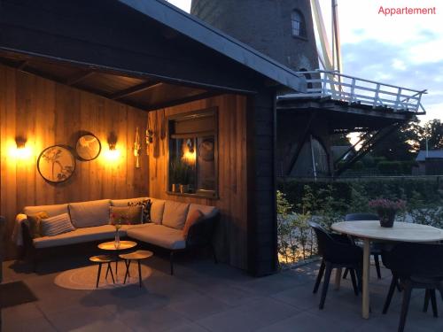 a patio with a couch and a table at Onder de Molen in Garderen