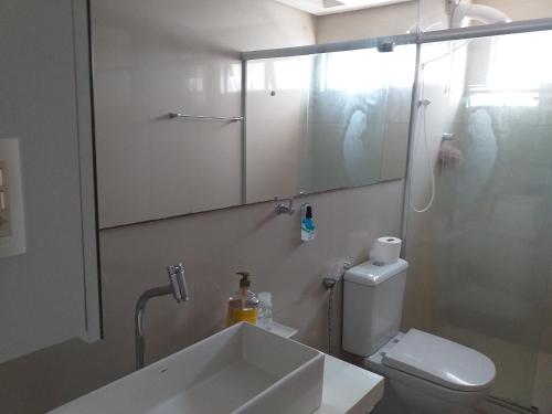 a bathroom with a sink and a toilet and a mirror at Quarto TRIPLO CONFORTO HH em RECIFE in Recife