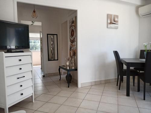 a living room with a television and a dining room table at T2 Terrasse vue mer in Six-Fours-les-Plages