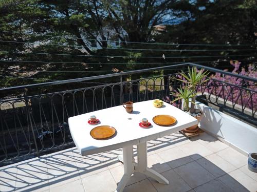 T2 Terrasse vue mer في سي-فور-لي-بلاج: طاولة بيضاء عليها طعام على شرفة