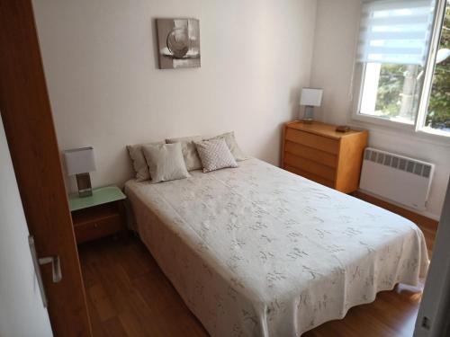 sypialnia z łóżkiem, 2 szafkami nocnymi i oknem w obiekcie T2 Terrasse vue mer w mieście Six-Fours-les-Plages