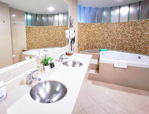 a bathroom with two sinks and a bath tub at Quorum Córdoba Hotel, Resort Urbano in Cordoba
