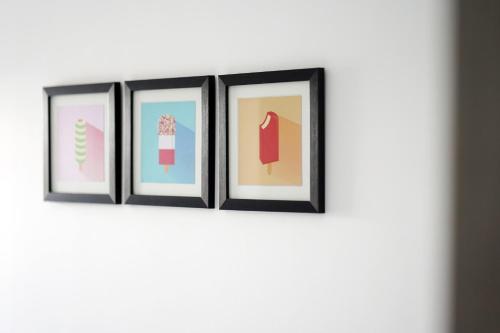 a row of four framed pictures on a wall at 11 Breakwaters Way - Sandown in Sandown