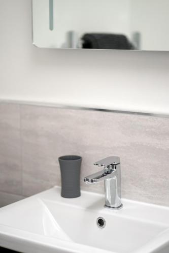 a bathroom sink with a faucet and a mirror at 11 Breakwaters Way - Sandown in Sandown