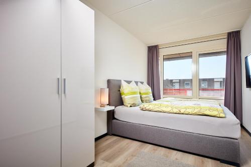 a bedroom with a bed and a window at Appartement Amelanderoase 83 im Amelander Paradijs in Buren
