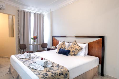een hotelkamer met een groot bed met handdoeken erop bij Tower Franca Hotel in Franca