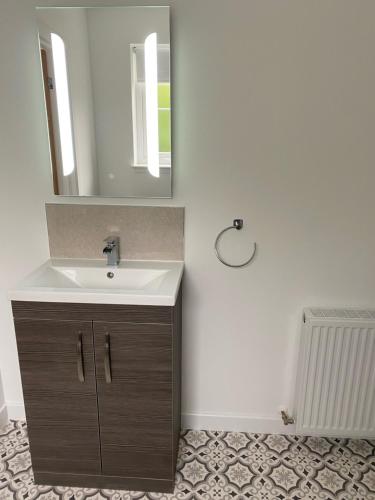 a bathroom with a sink and a mirror at Loch Ness House Blairbeg in Drumnadrochit