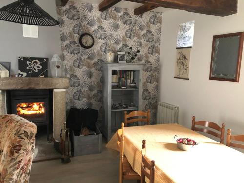 a living room with a table and a fireplace at Gite de la Huberderie in Quettehou