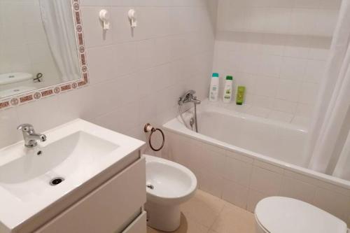 a white bathroom with a sink and a toilet at CASA LAGO in Arcos de la Frontera