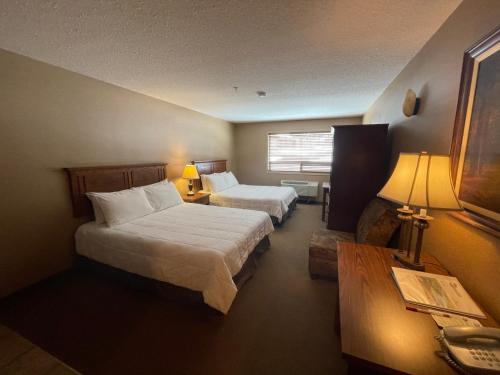 a hotel room with two beds and a table at Elkwater Lake Lodge and Resort in Elkwater