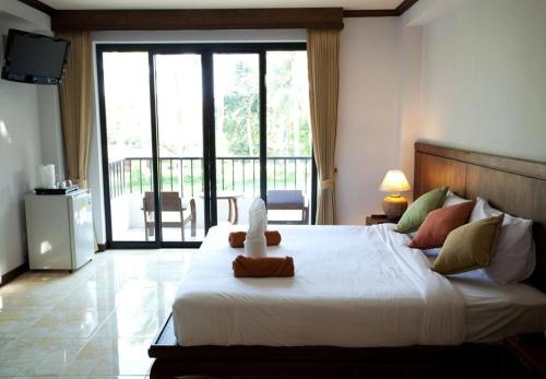 a bedroom with a large white bed with a balcony at Coconut Beach Resort in Lamai