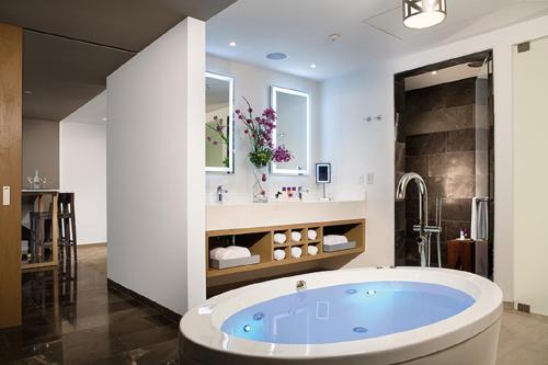 un bagno con una grande vasca blu in una stanza di Secrets Riviera Cancún Resort & Spa - Adults Only - All inclusive a Puerto Morelos