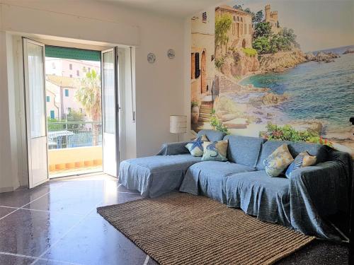a living room with a blue couch and a painting at Mare & Relax in Albissola Marina