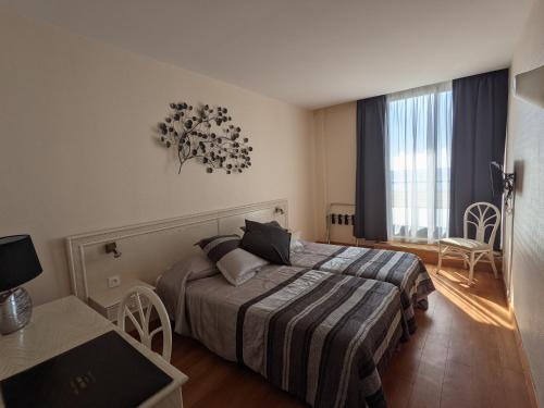 a hotel room with a bed and a window at Hotel Mira-Mar in Valras-Plage