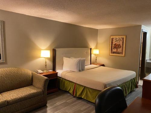 una habitación de hotel con una cama y una silla en Travelodge by Wyndham Laurel Ft Meade Near NSA, en Laurel