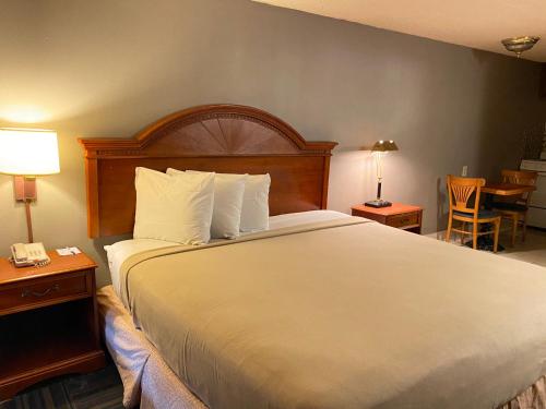 a hotel room with a large bed with white sheets at Travelodge by Wyndham Laurel Ft Meade Near NSA in Laurel