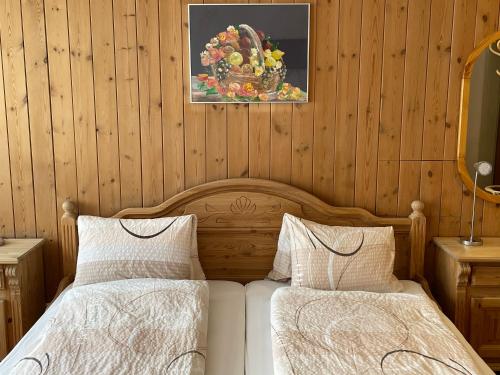 Hotel Scuol في سكول: غرفة نوم بسريرين ولوحة على الحائط