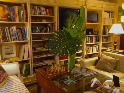 a living room with a table and a palm tree at Taller de artista in Colonia del Sacramento