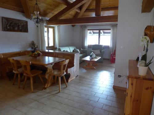 een keuken en een woonkamer met een tafel en stoelen bij La Mansarda di nonna Delfa in Pinzolo