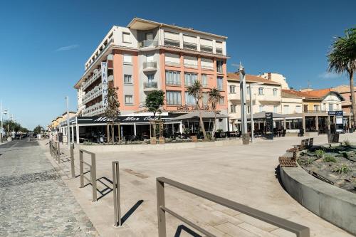 a large building on a city street with stores at Hotel Mira-Mar in Valras-Plage