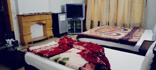 a hotel room with two beds and a television at Butt Lodges 3 in Islamabad