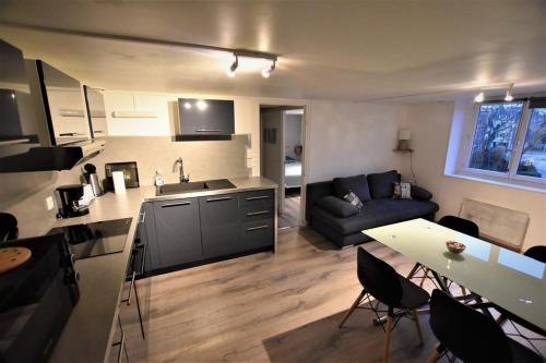 uma cozinha e sala de estar com um sofá e uma mesa em Appartement Dunkerque Centre 4 personnes - Parking gratuit- em Dunkerque