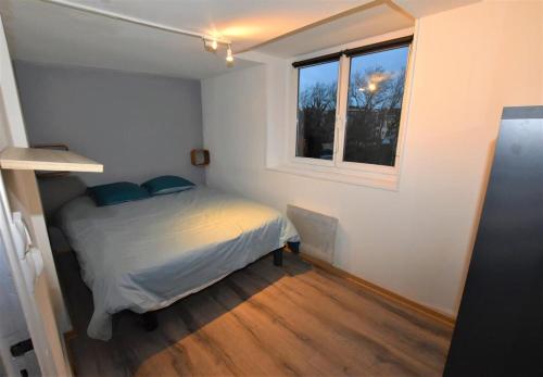 ein kleines Schlafzimmer mit einem Bett und einem Fenster in der Unterkunft Appartement Dunkerque Centre 4 personnes - Parking gratuit- in Dunkerque