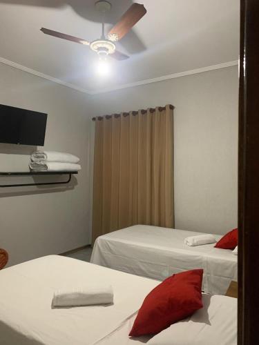 a bedroom with two beds and a ceiling fan at Perea Hotel in São Carlos