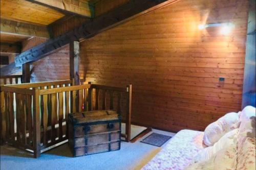 Cette chambre est dotée d'un mur en bois et d'un escalier en bois. dans l'établissement Superbe appartement au centre de Samoens, à Samoëns