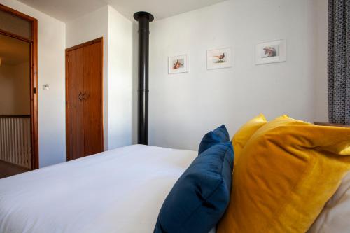 a bedroom with a bed with blue and yellow pillows at The Old Chapel Leyburn in Leyburn