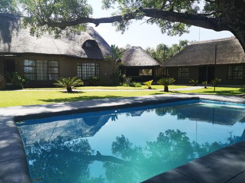 a swimming pool in front of a house at Sasavona Game Lodge in Warmbaths