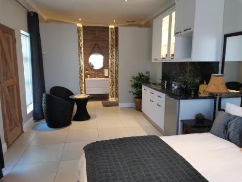 a large bedroom with a bed and a kitchen at Brewer Place in Port Elizabeth
