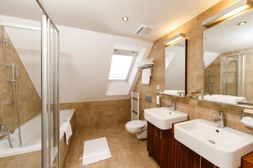 a bathroom with a sink and a toilet and a shower at BEIGLI Hotel & Garden in Bratislava