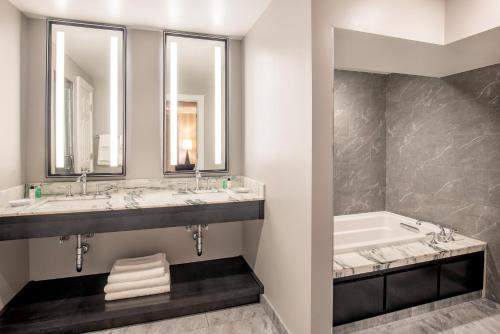 a bathroom with two sinks and a tub at The Equinox Golf Resort & Spa in Manchester