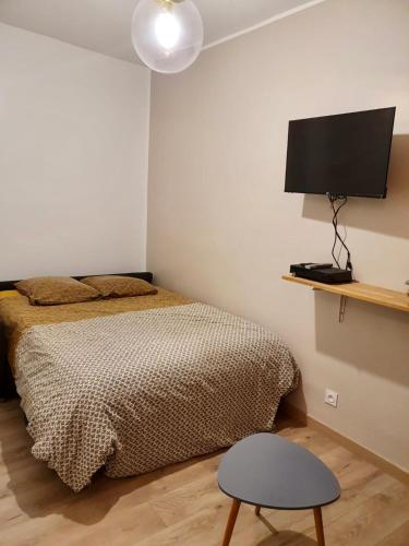 une chambre avec un lit et une télévision au mur dans l'établissement Home Sweet Home Sacré-Coeur Montmartre, à Paris